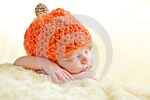 Newborn wearing pumpkin hat