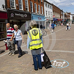 Woman wearing Corvid-19 jacket. Keep distance.