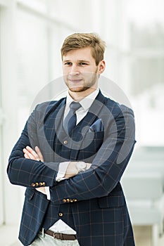 Newcomer businessman in a business suit stands near the window,