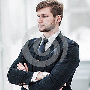 Newcomer businessman in a business suit stands near the window,