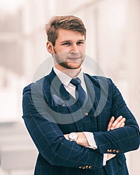 Newcomer businessman in a business suit stands near the window,