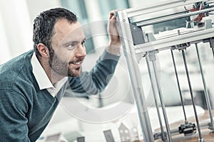 Happy nice engineer looking at the 3d printing machine