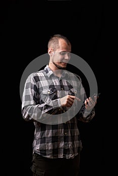 Newest technologies and development of society, communication between people. Young casual man reading something on his