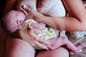 A newly born baby. The first days of life. Happy baby and mom at home. Feeding, wiping, hygienic procedures