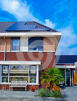 Newly build houses with solar panels attached on the roof against a sunny sky