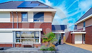 Newly build houses with solar panels attached on the roof against a sunny sky