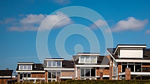 Newly build houses with solar panels attached on the roof against a sunny sky