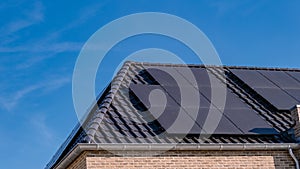 Newly build houses with solar panels attached on the roof against a sunny sky