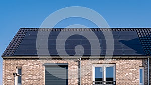 Newly build houses with solar panels attached on the roof against a sunny sky