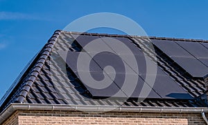 Newly build houses with solar panels attached on the roof against a sunny sky