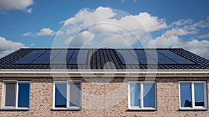 Newly build houses with solar panels attached on the roof against a sunny sky