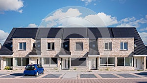 Newly build houses with solar panels attached on the roof against a sunny sky