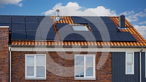 Newly build houses with solar panels attached on the roof against a sunny sky