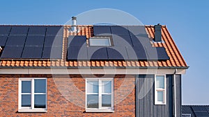 Newly build houses with solar panels attached on the roof against a sunny sky