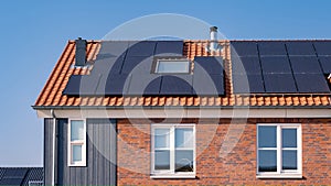 Newly build houses with solar panels attached on the roof against a sunny sky