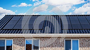 Newly build houses with solar panels attached on the roof against a sunny sky