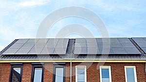 Newly build houses with solar panels attached on the roof against a sunny sky