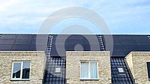 Newly build houses with solar panels attached on the roof against a sunny sky