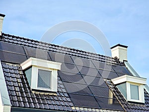 Newly build houses with solar panels attached on the roof against a sunny sky