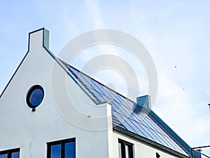 Newly build houses with solar panels attached on the roof against a sunny sky