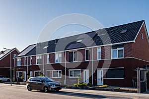 Newly build houses with solar panels attached on the roof against a sunny sky Close up of new building with black solar