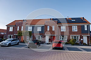 Newly build houses with solar panels attached on the roof against a sunny sky Close up of new building with black solar