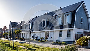 Newly build houses with solar panels attached on the roof against a sunny sky Close up of new building with black solar