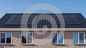 Newly build houses with solar panels attached on the roof against a sunny sky, housing market