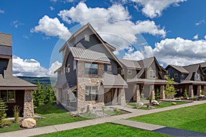 Newly build modern and rustic home from exterior in natural brown and grey colors with walkways, green grass and natural stone