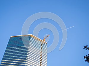 A newly built house. Glazed skyscraper. Reflection of the sky in the windows. Multi-apartment modern housing