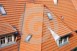 Newly covered house roof with light red folded tiles as well as roof- and dormer windows