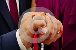 Newly engaged couple holding hands with a ribbon