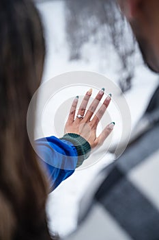 Newly Engaged Couple Showing off Engagement Ring in Winter Wonderland