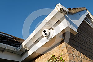 Newly installed, dome type night and day colour CCTV camera attached to the eaves of a private bungalow.