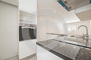 Newly installed kitchen with shiny countertops, glass and stainless