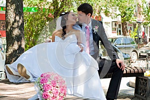 Newly-married couple on a bench in park