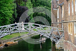 A newly married couple celebrate on the Mathematical Bridge across the river Cam