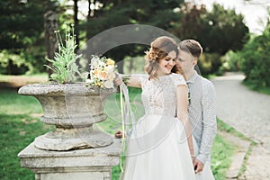 Newly married couple running and jumping in park while holding hands