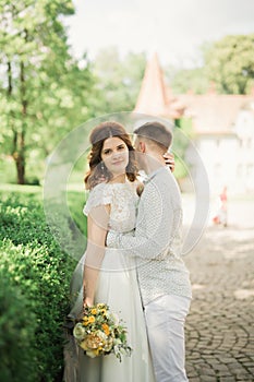 Newly married couple running and jumping in park while holding hands