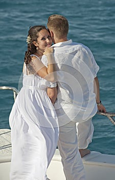 Newly married couple stood on the bow of a boat