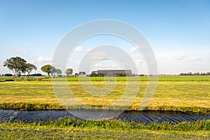 Newly mowed grassland in the foreground with a modern farm with