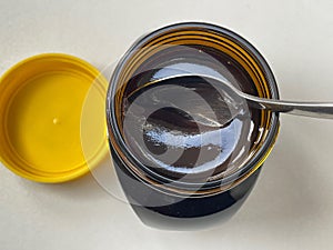 Newly opened yeast extract marmite jar with spoon photo