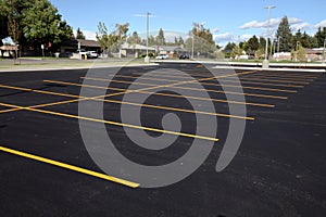 Newly painted yellow stripes create parking stalls in a new parking lot.