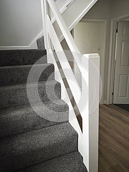 Newly renovated hallway and staircase with fresh white paint and carpets - ready for sale or rental on the UK market.