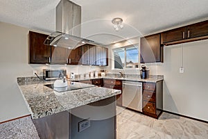 Newly renovated kitchen with dark wood cabinets and granite counter tops