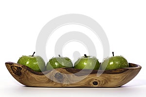 Newly washed green apples in olive wood bowl