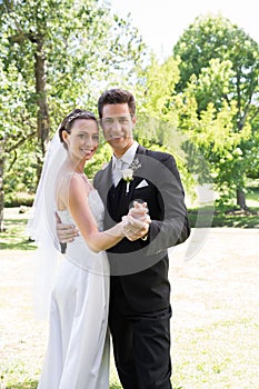 Newly wed couple dancing in garden