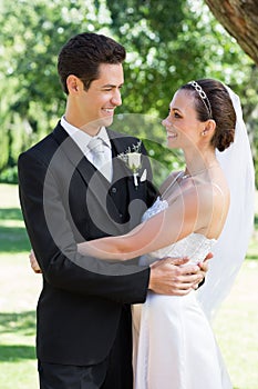 Newly wed couple embracing each other in garden photo