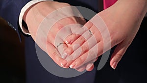 Newly wed couple`s hands with wedding rings. Bride and groom with wedding rings. Hands and rings on wedding bouquet