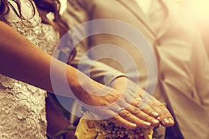Newly wed couple`s hands with wedding rings. Vintage tone